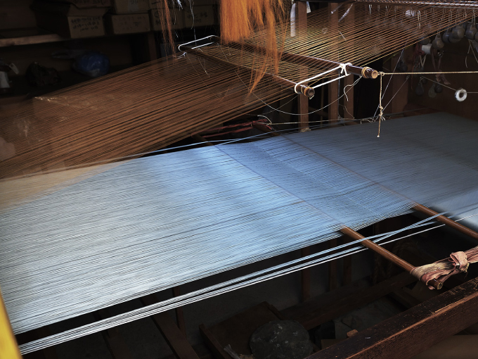 三越伊勢丹に掲載の西陣織金襴の手織りの製織現場の写真