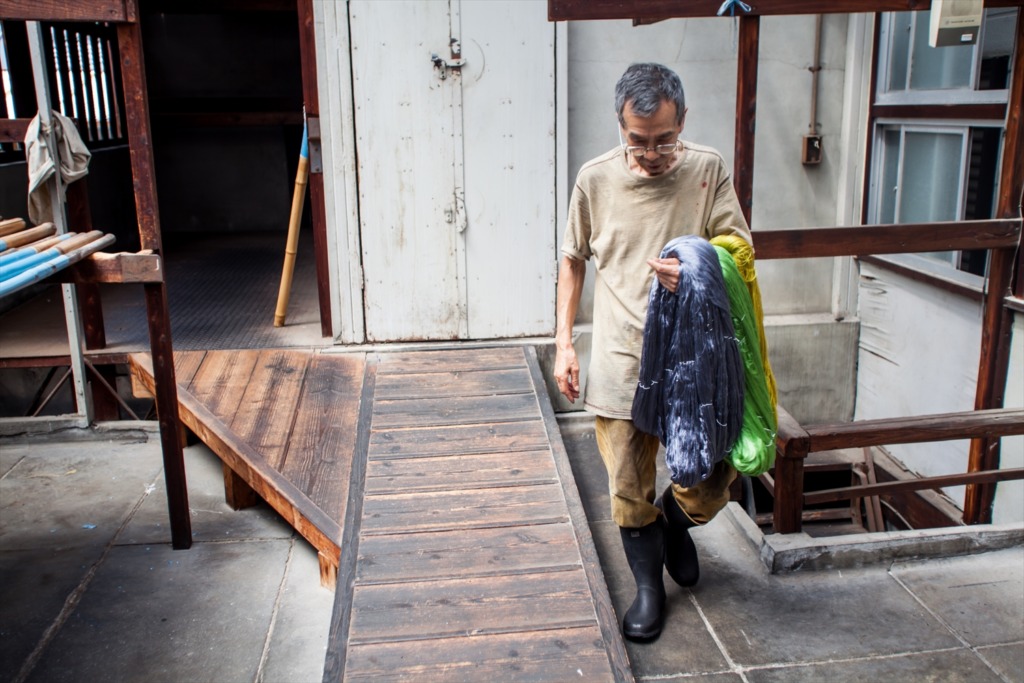 染料を計量することなく絹糸を染め上げる、経験が必要な「勘染」の職人の仕事風