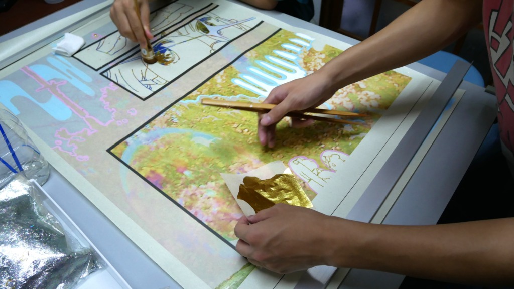 若きクリエイター　ぐらにゅーとーの二人が西陣織の引箔に箔を乗せる