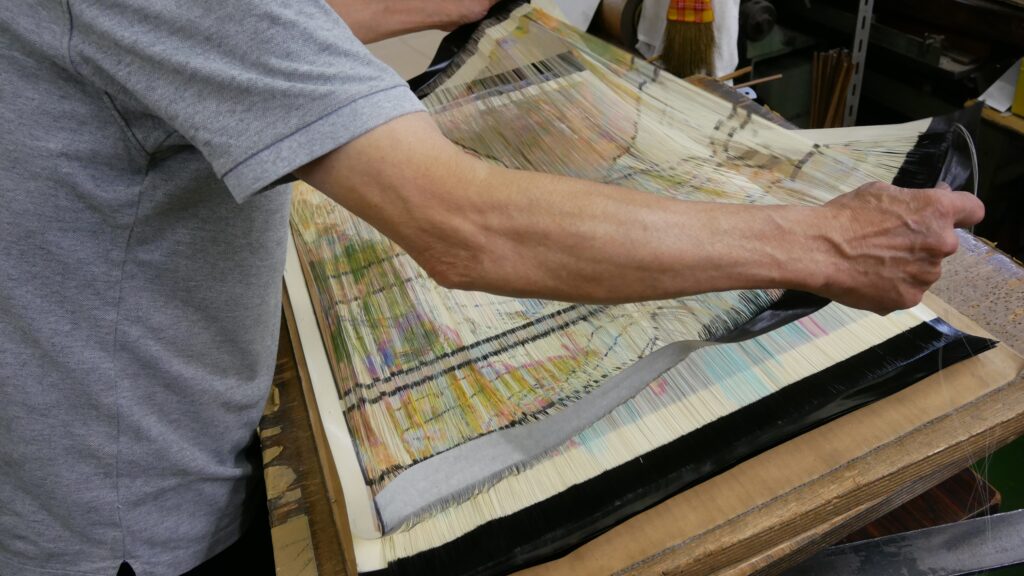 西陣織に使われる引箔を裁断している写真
