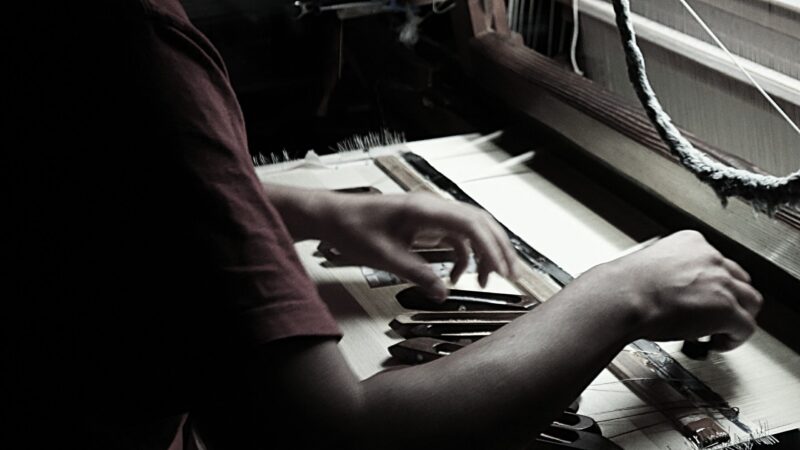 手織りで西陣織金襴を織っている伝統工芸士岡本圭司の手元写真